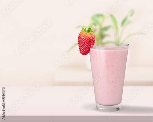 Glass of strawberry yogurt on color pastel background