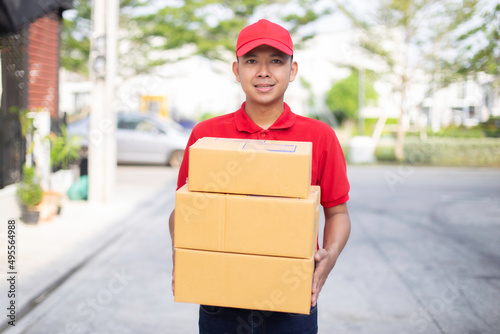  smiling young delivery man standing with parcel box