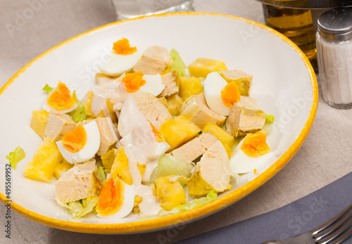 Dish with appetizing chicken salad, eggs and pineapples. High quality photo © JackF