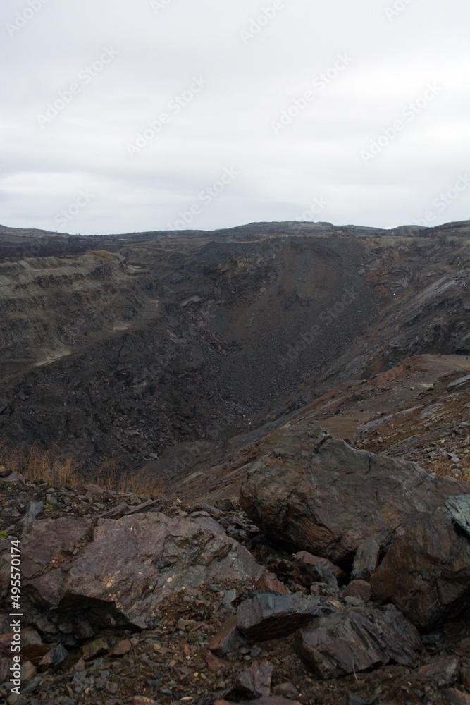 Old abandoned huge coal pit. Nature pollution. Ruins and stones. Ruins and huge mountains of dirty rock. Old abandoned huge coal pit. Nature pollution. Ruins and stones. Ruins and huge mountains of dirty rock.