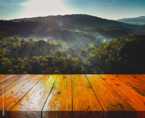 An old wooden table with a mountain and fog backdrop.