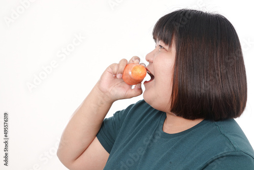 Fat woman eating carrots to lose weight. Health care concept, eat healthy food. white background
