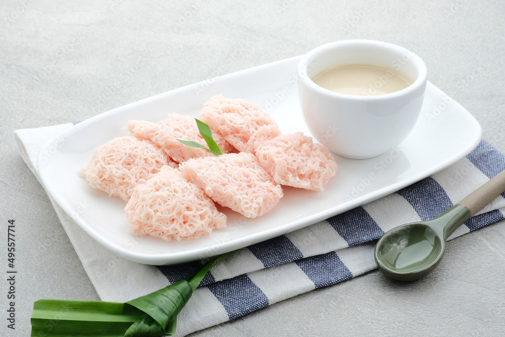 Kue Putu Mayang is traditional Indonesian snack made from rice flour strands curled up into a ball, served with coconut milk and palm sugar. Selected focus.
Kue Putu Mayang is traditional Indonesian snack made from rice flour strands curled up into a ball, served with coconut milk and palm sugar. Selected focus.