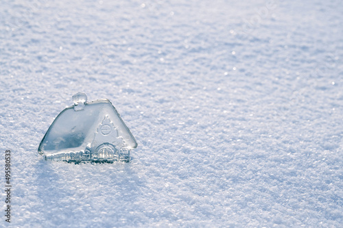 beautiful little glass, crystal house on background of white snow. Concept of real estate investment. Take out mortgage. Real estate business. Copy space