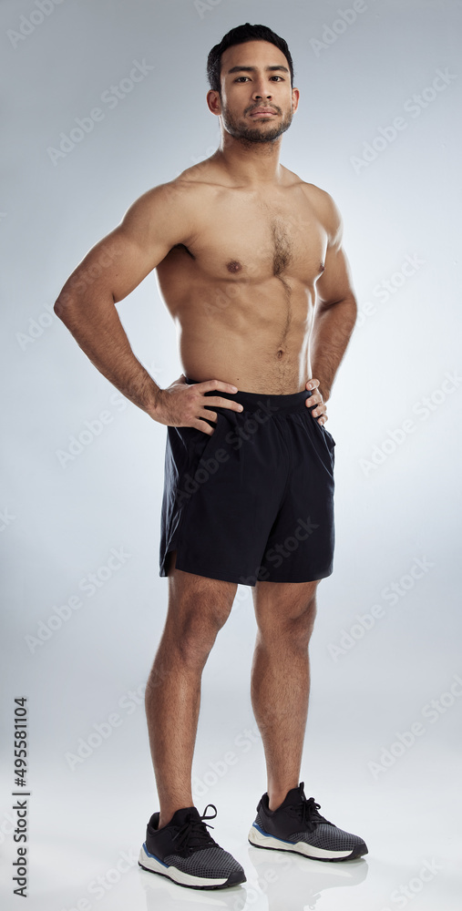 Feeling strong and muscular. Shot of a handsome young man against a studio background. Feeling strong and muscular. Shot of a handsome young man against a studio background.