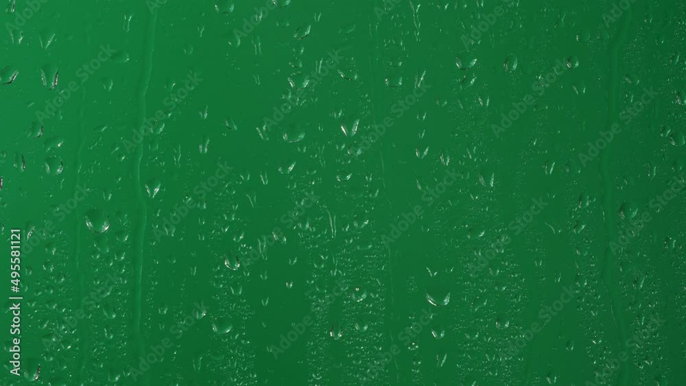 Water rainfall, rain drops falling on window glass over chroma key green screen