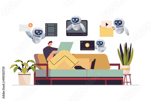 man with robots watching videos on laptop online education e-learning video tutorials live streaming artificial intelligence