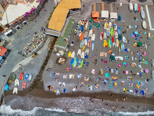 Overhead aerial view of people relaxing on a beautiful beach.