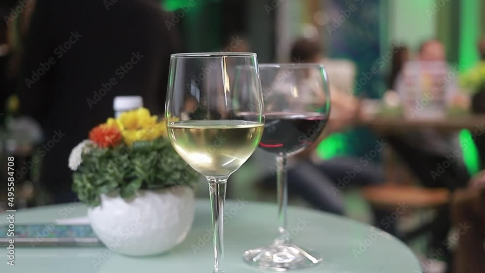 two wine glasses on table with background of blurred social event. two wine glasses on table with background of blurred social event.