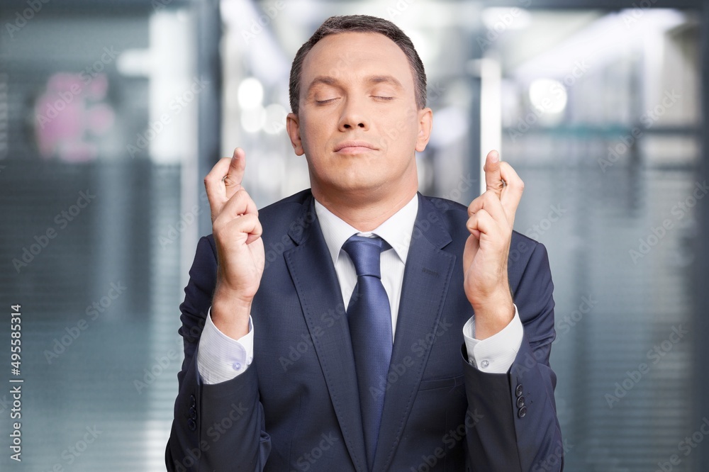 American young hopeful man in office with crossing fingers praying says prayer hopes for future possibility, hope faith concept. American young hopeful man in office with crossing fingers praying says prayer hopes for future possibility, hope faith concept.