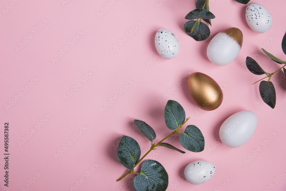 Easter eggs with green eucalyptus branches on a pink background. Holiday concept. Happy Easter greeting card