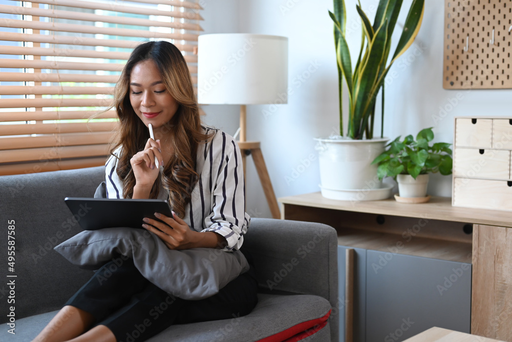 © Prathankarnpap - Cheerful young woman surfing internet, shopping online on digital tablet. © Prathankarnpap - Cheerful young woman surfing internet, shopping online on digital tablet.