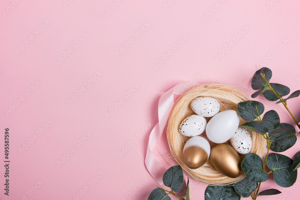 Easter eggs with green eucalyptus branches on a pink background. Holiday concept. Happy Easter greeting card