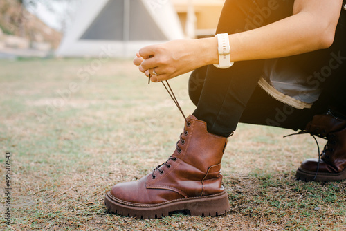 Traveller woman tying shoelace boot at camping,Enjoy and camping concept