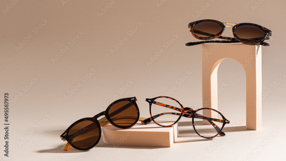 Trendy sunglasses of different design and eyeglasses on beige background. Copy space. Sunglasses and spectacles sale concept. Optic shop promotion banner. Eyewear fashion. Minimalism - obrazy, fototapety, plakaty 