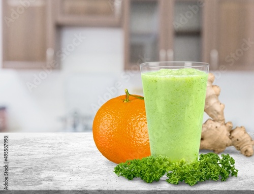 Detox juice, glass with green juice on a board, small fruit ingredient for the juice