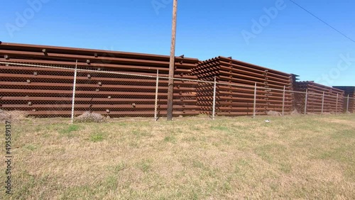 POV driving past metal panels stockpiled for building the border wall between Texas USA and Mexico; near McCallen Texas; concepts of national defense, border security, and Trump's build the wall