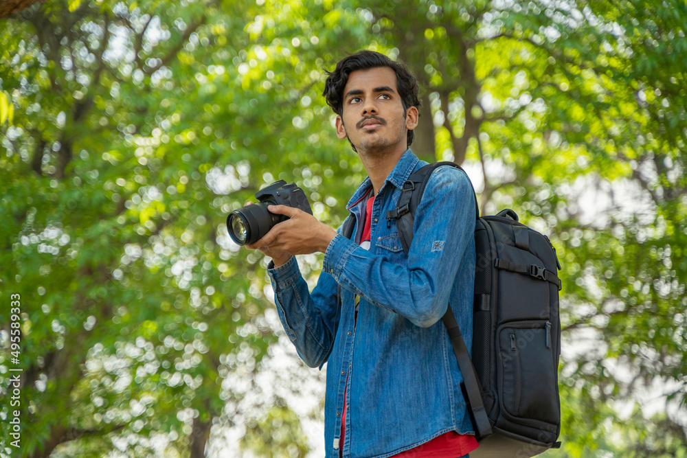 Young Indian photographer with his professional camera Young Indian photographer with his professional camera