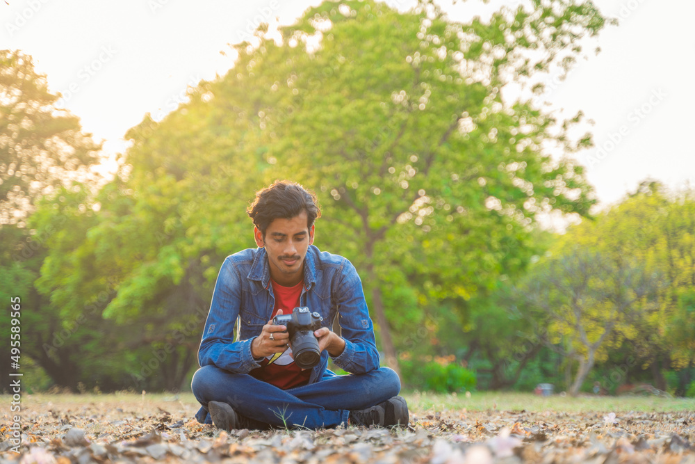 Samolepka Young photographer checking photos in the camera