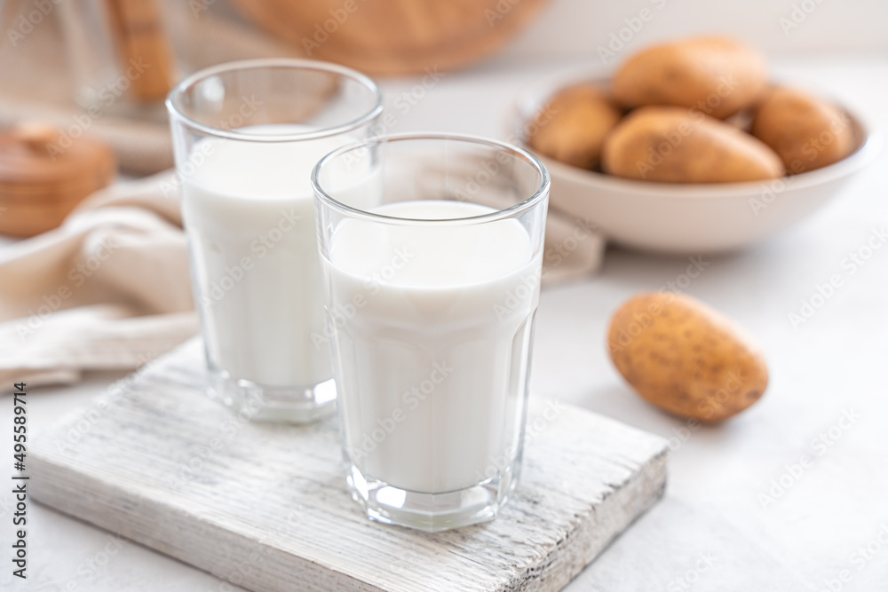 Vegetarian potato milk in two glasses on a light background. Vegetarian potato milk in two glasses on a light background.