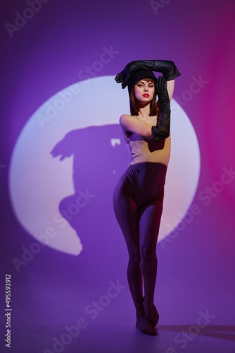 Pretty young female posing on stage spotlight silhouette disco studio model unaltered