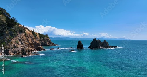 Flight towards Otama Bay headland reveals rugged rock faces and jagged reef photo