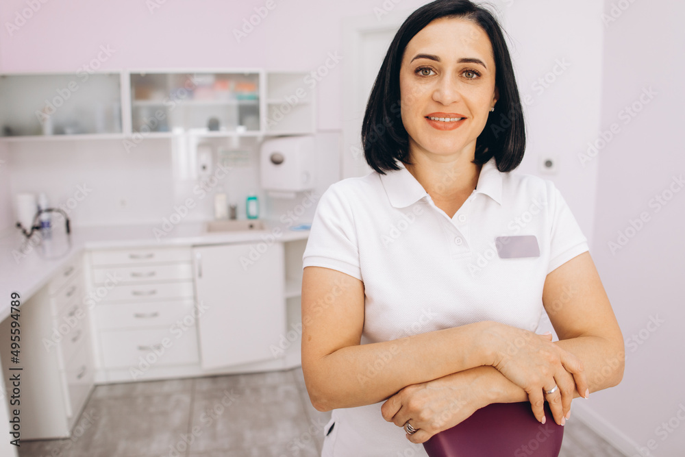 Beautiful female dentist smiling at dental clinic Beautiful female dentist smiling at dental clinic