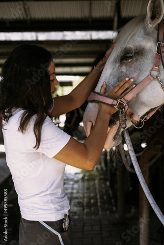 A young woman and a horse, feelings, care, affection, tenderness, a woman hugs and kisses a horse. Close up of happy young woman hugging her horse.