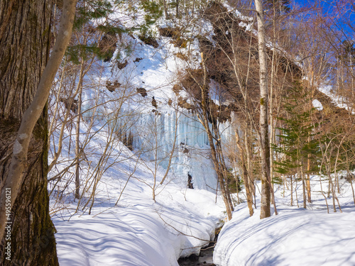 Icefalls seen beyond a snow-covered stream (Shiraoi, Hokkaido, Japan) photo