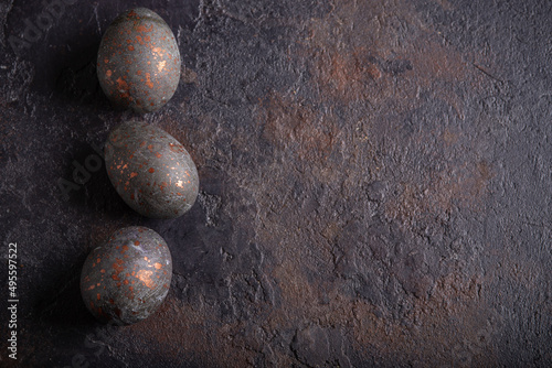 Easter hibiscus tea-dyed chicken eggs on a dark grunge background. Copy space. Top view