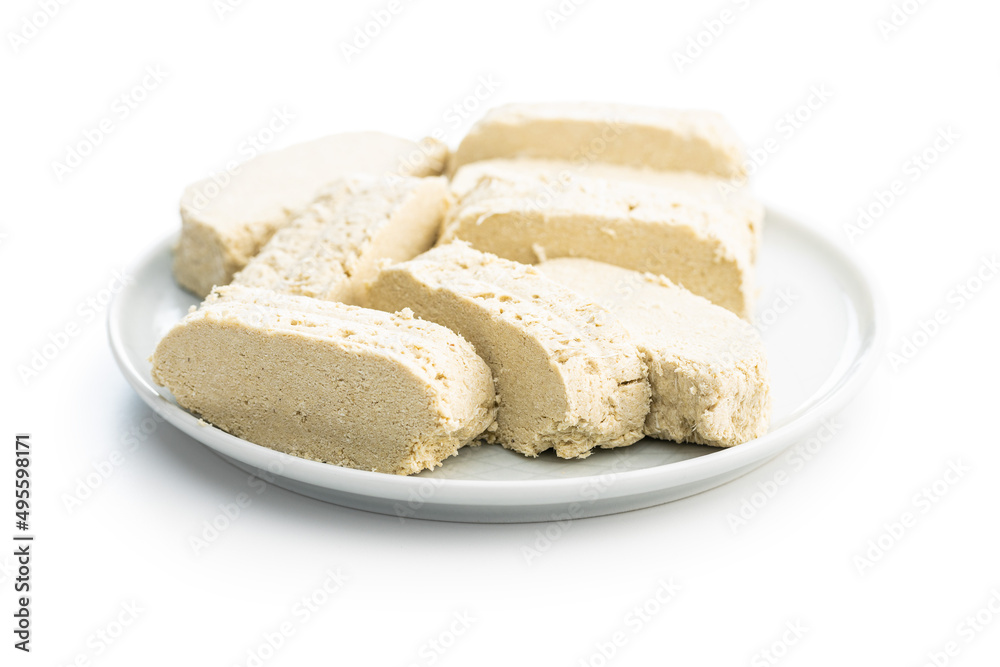 Sweet tahini halva on plate. Turkish dessert isolated on white background. Sweet tahini halva on plate. Turkish dessert isolated on white background.