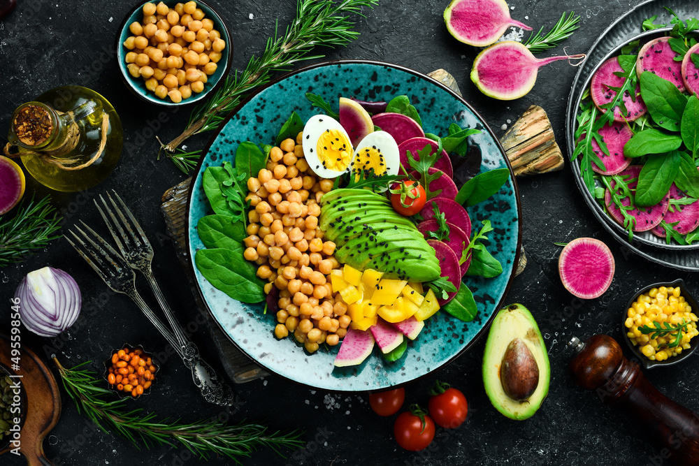 Diet salad: Chickpeas, spinach, radishes, avocados and eggs. Bowl Buddha. Vegan food. Top view. On a stone background. Diet salad: Chickpeas, spinach, radishes, avocados and eggs. Bowl Buddha. Vegan food. Top view. On a stone background.