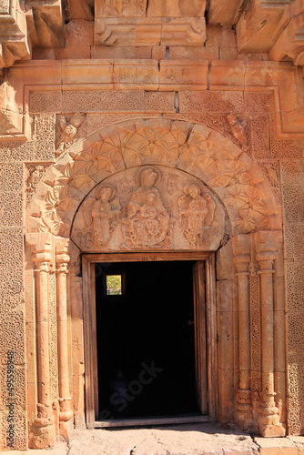 Entrance door with decorative sculpture of Vergin Mary and baby Jesus in Noravank, Armenia photo