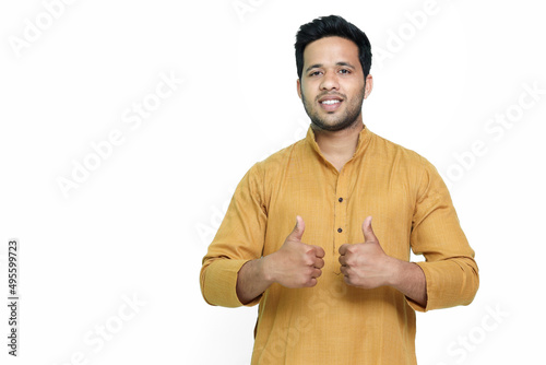 Attractive Young Indian Man Showing Thumbs Up Sign, Isolated on White and Wearing a Kurta.