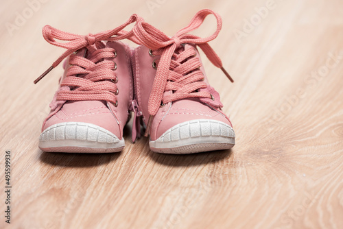 pair of pink baby shoes on the floor