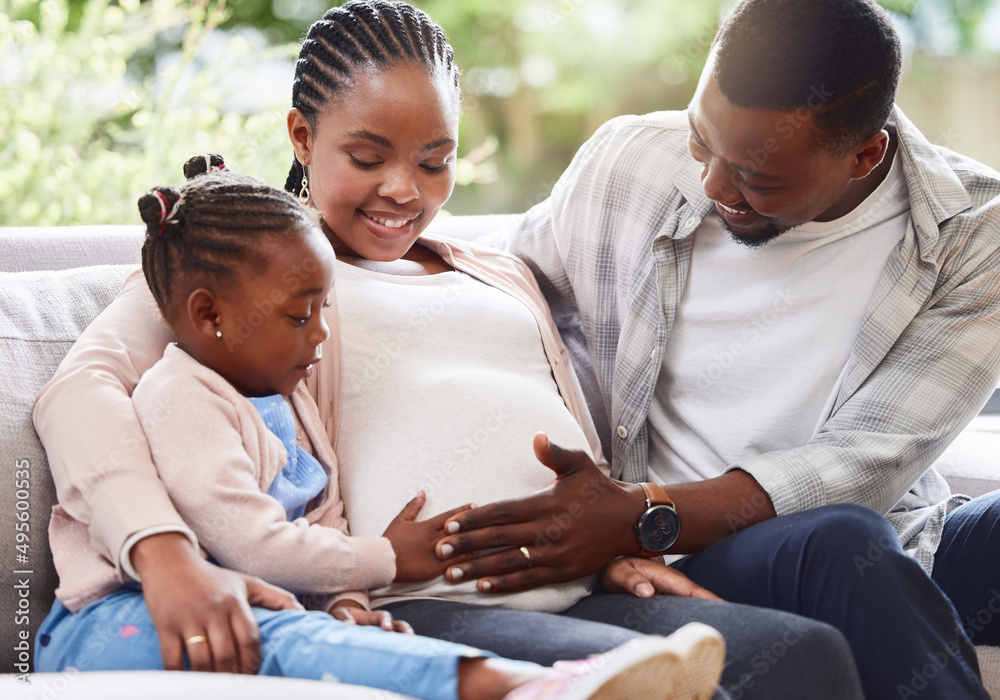 Obraz premium They couldnt be happier. Cropped shot of an attractive young pregnant woman sitting on the sofa at home with her husband and daughter.