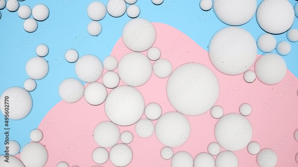 Different sized light grey drops of white cream floating in transparent liquid on blue and pink background | Background for skin care products
