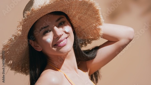 Photos Beauty portrait of young brunette asian woman with sunscreen on her cheeks in a