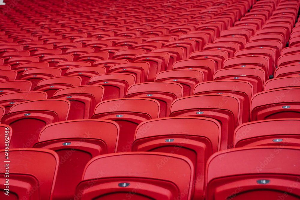 Fototapeta premium Rows of seats in a football stadium. Bright red stadium seats