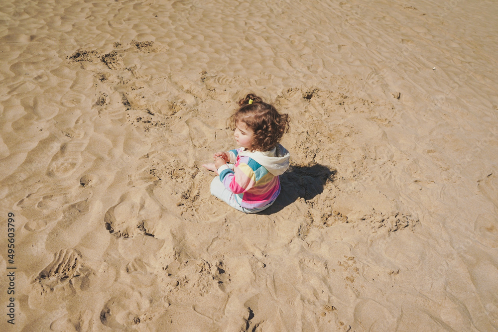 Young toddler playing with the sand at the beach Young toddler playing with the sand at the beach