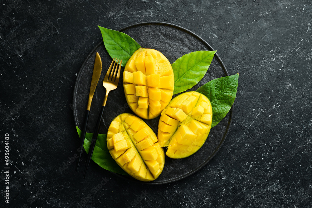 Mango. Fresh juicy ripe mango cut into slices on a plate. Tropical fruits. Top view with copy space.