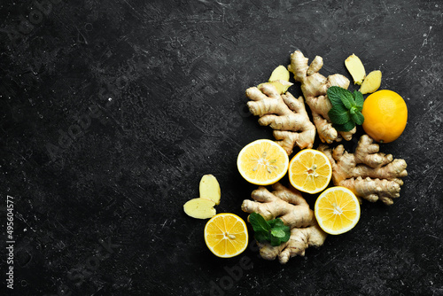 Fresh ginger, mint and lemon on a black background. Top view. On a stone background. photo