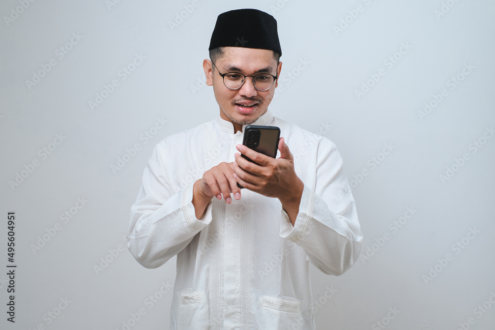 Happy asian muslim man holding and pointing on phone cellular Happy asian muslim man holding and pointing on phone cellular