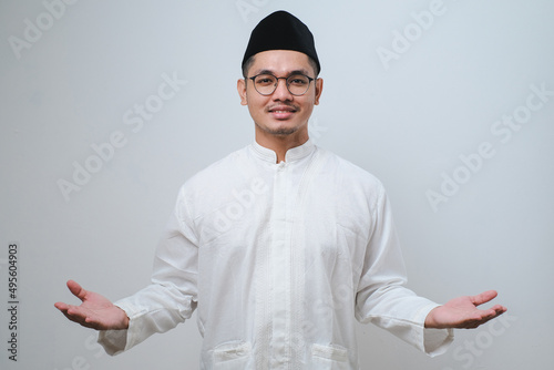 Asian man smiling happy to greeting during Ramadan celebration with both arms open photo
