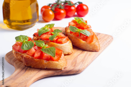 Italian tomato and cheese bruschetta. Tapas, antipasti with chopped vegetables, herbs and oil on grilled ciabatta and baguette bread.