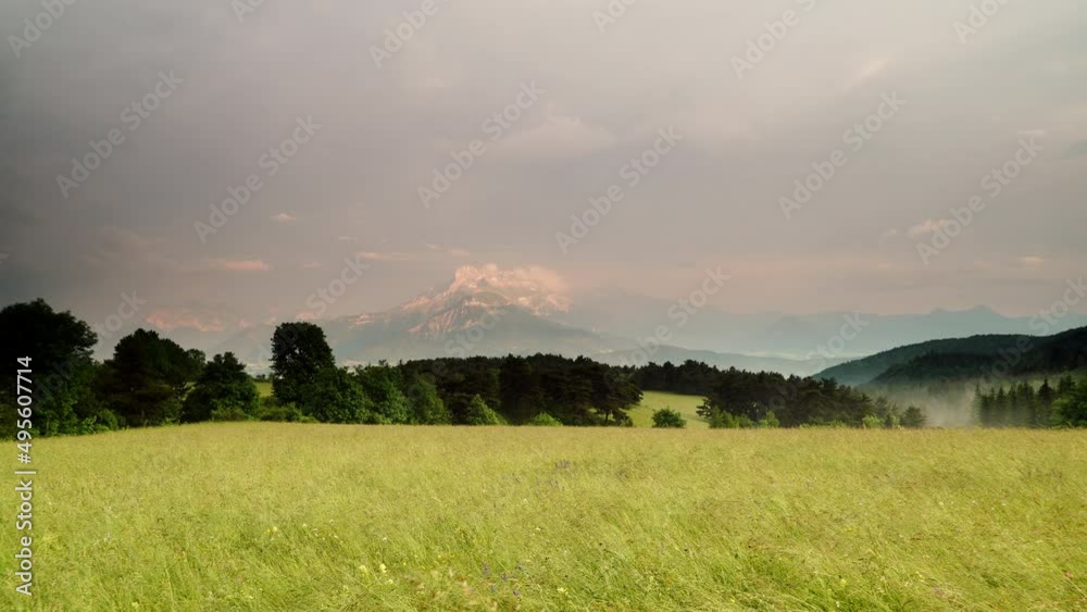 Summer meadow and clouds over mountains in the distance. Grande Tete de L'Obiou, Dauphine Prealps in south-western part of Alps, France. Summer meadow and clouds over mountains in the distance. Grande Tete de L'Obiou, Dauphine Prealps in south-western part of Alps, France.