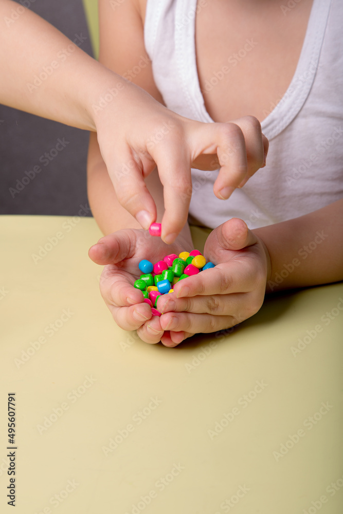 bright colorful sweets in children's palms