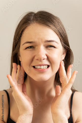 young female holds her hurting neck crvical lymph nodes