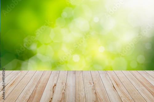 Wooden table with green natural background for design.