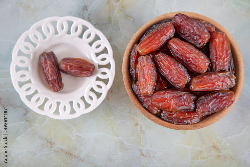 Bowl of dates fruit on colorful marble background, directly above Bowl of dates fruit on colorful marble background, directly above